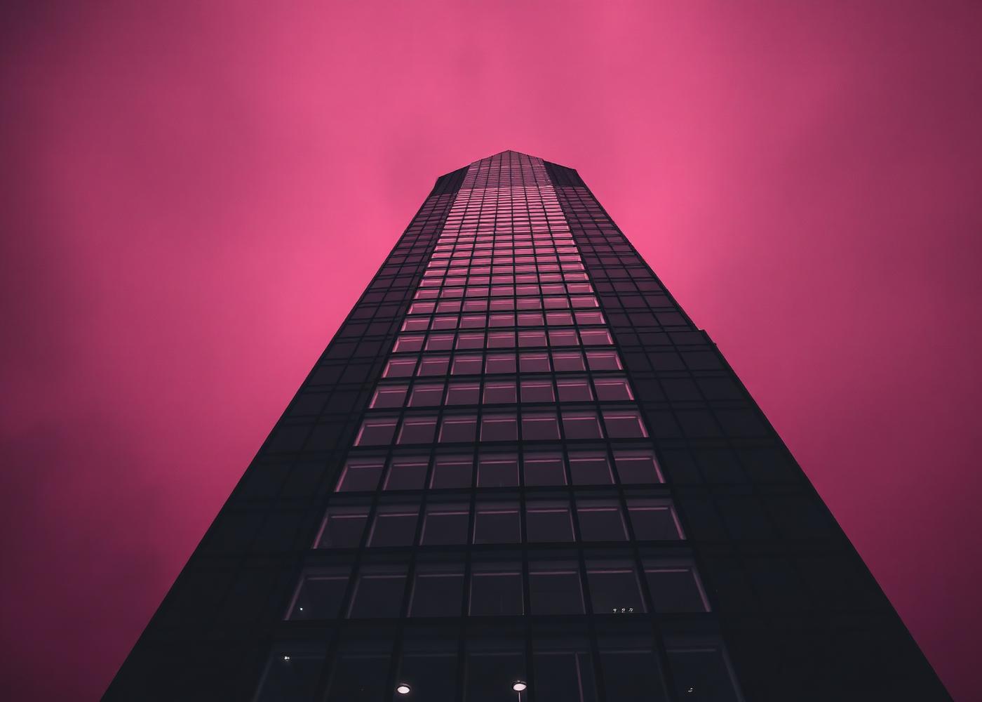 Skyscraper rising against a magenta sky